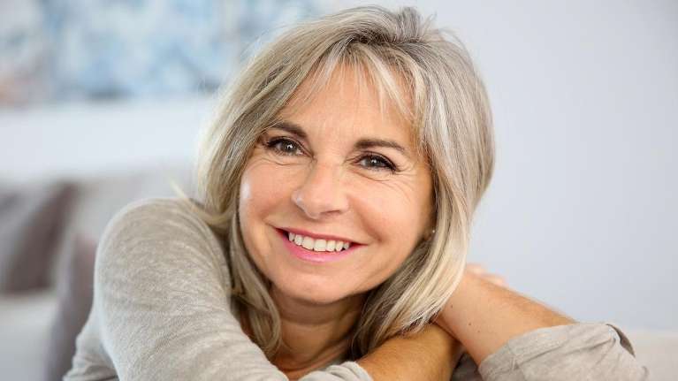 A elderly woman smiling after getting a Dental Bridges in Clayton, NC