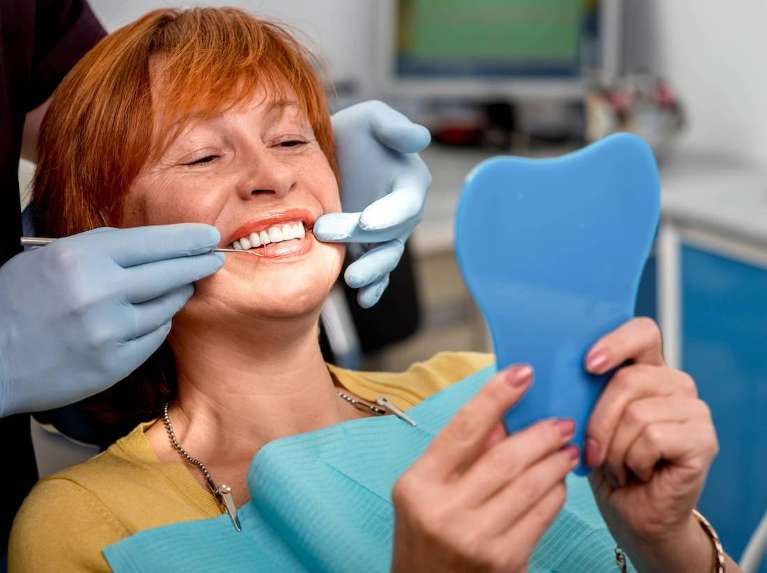 a middle aged lady getting dental crowns in Clayton, NC