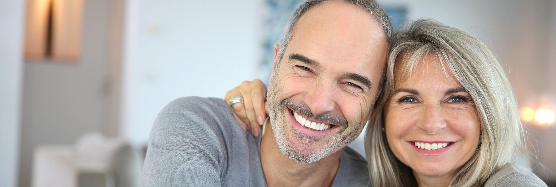 smiling couple with dental implants in clayton nc